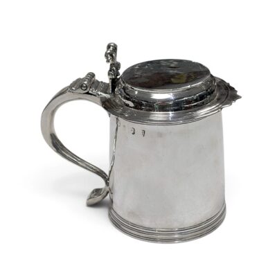 Silver tankard with flat hinged lid, scroll handle and moulded base, London 1707