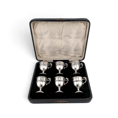 Six silver tot cups in their fitted case