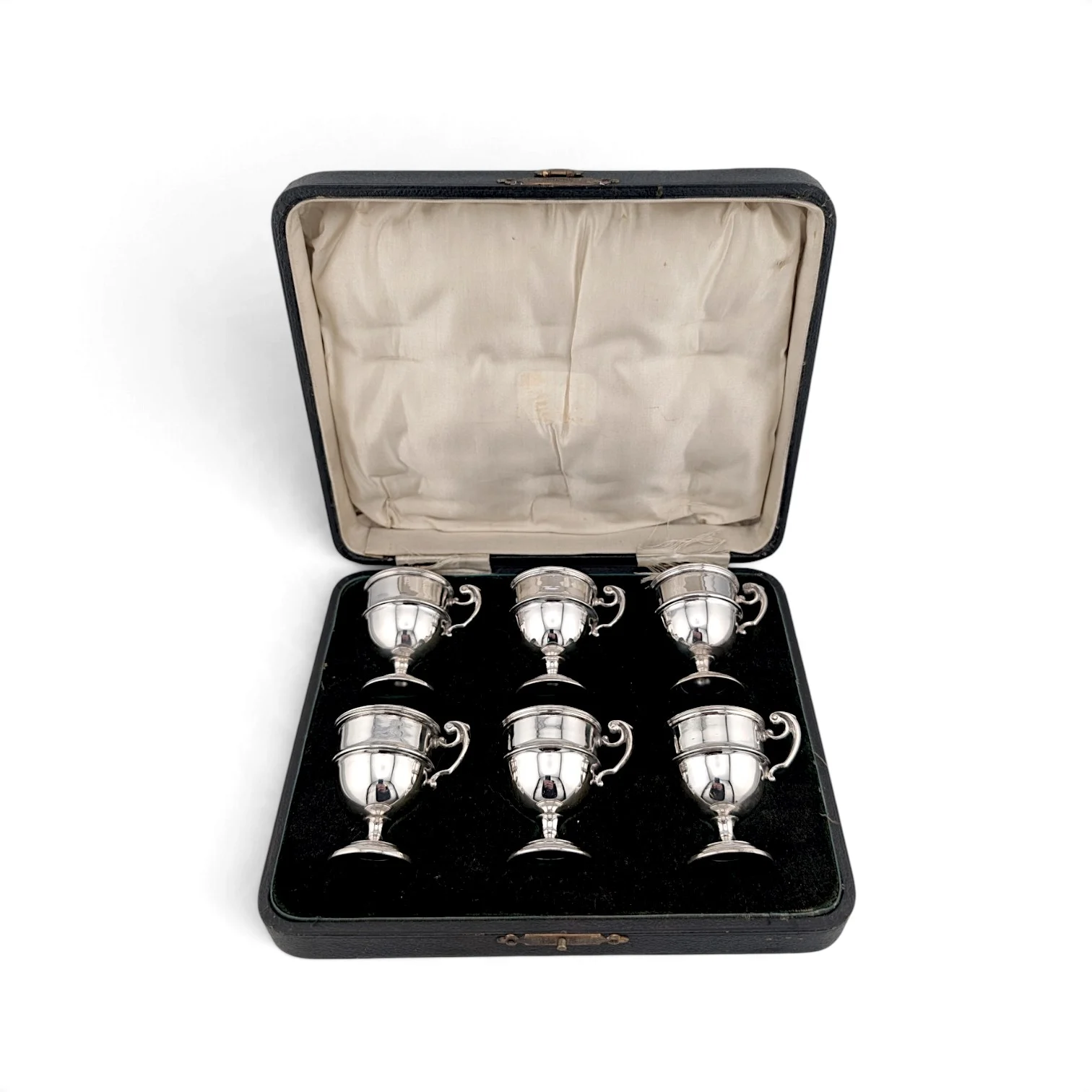 Six silver tot cups in their fitted case