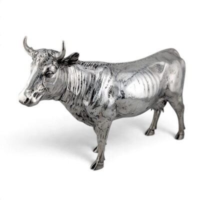 Silver cow figure standing, head turned slightly
