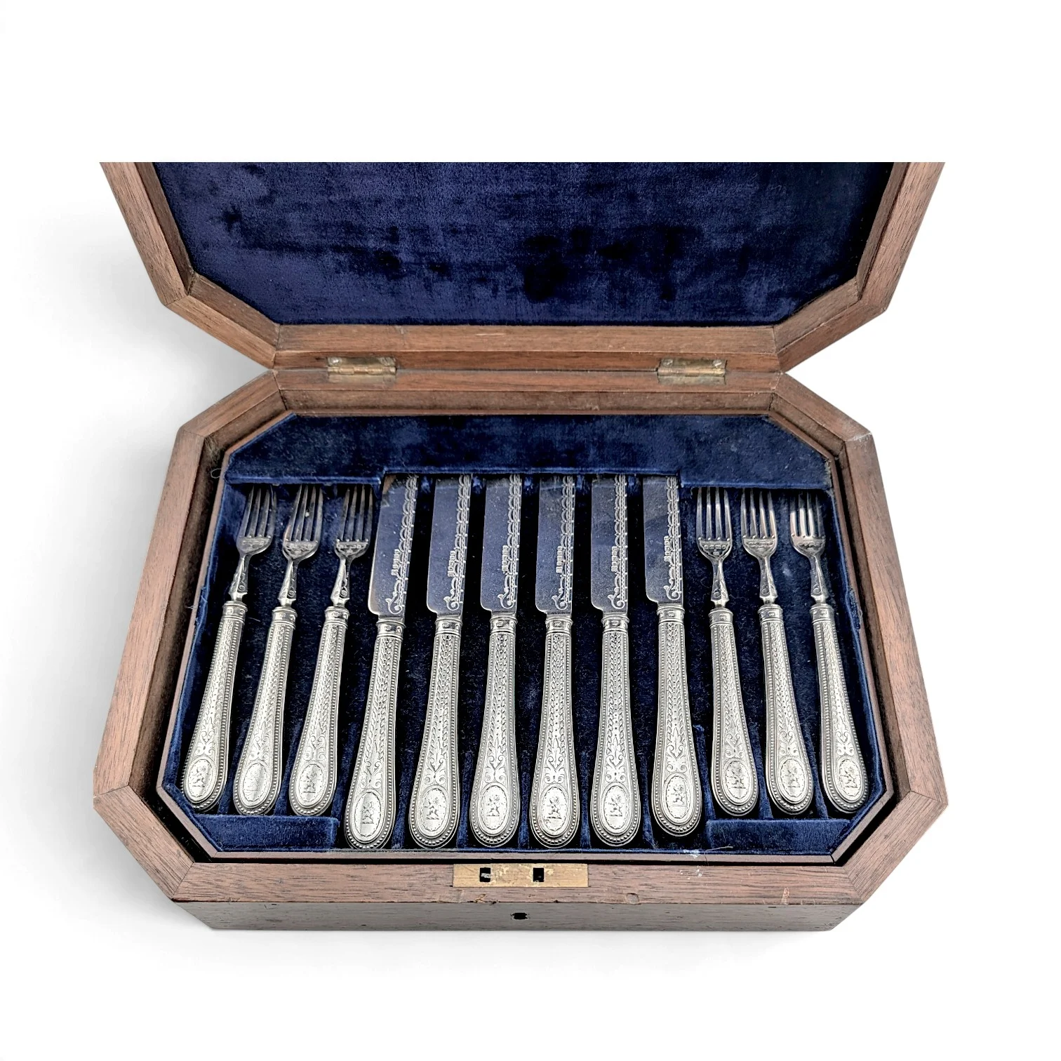 Close view of the engraved fish knives and forks in the open case