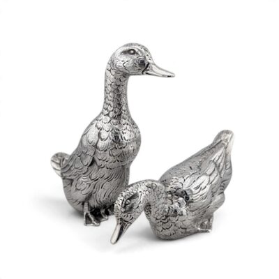 Pair of silver ducks, one standing upright and one resting