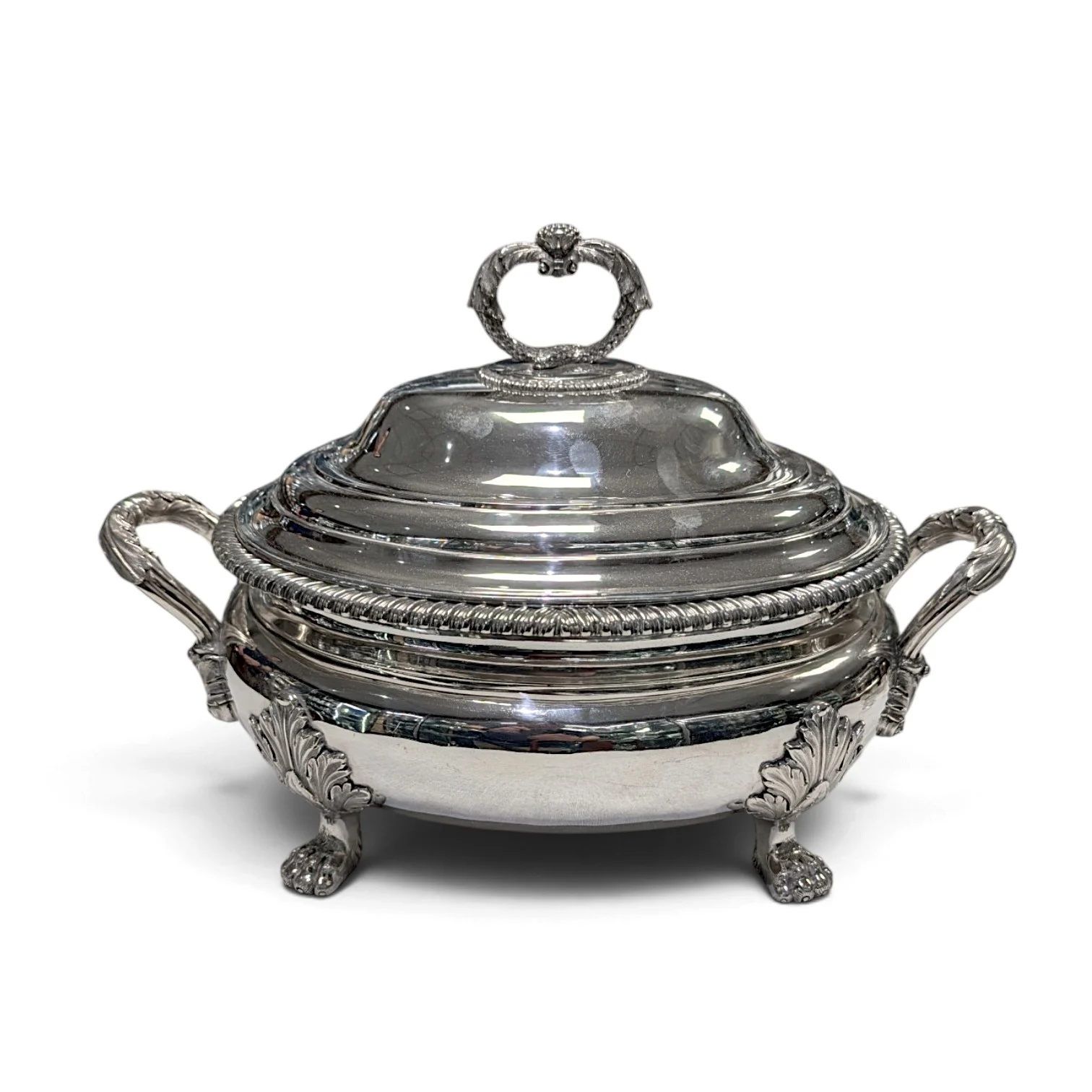 Silver soup tureen and cover with side handles on four feet