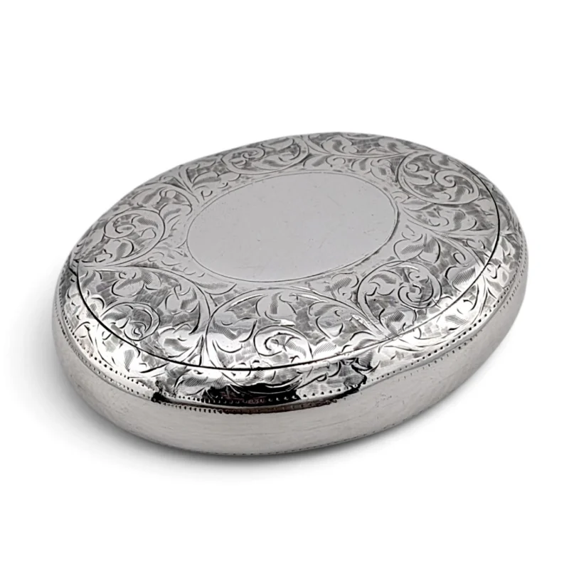 Oval silver tobacco box with an engraved scrolling lid